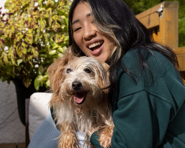 Um cão pequeno com a sua tutora